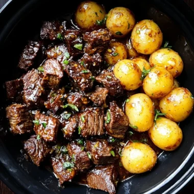 Garlic Butter Beef Bites served with crispy potatoes, garnished for flavor.