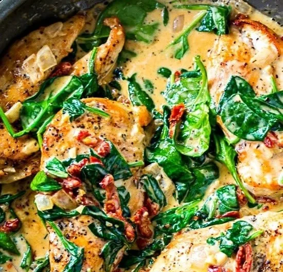 Low carb creamy Tuscan chicken dish served with fresh herbs and vegetables