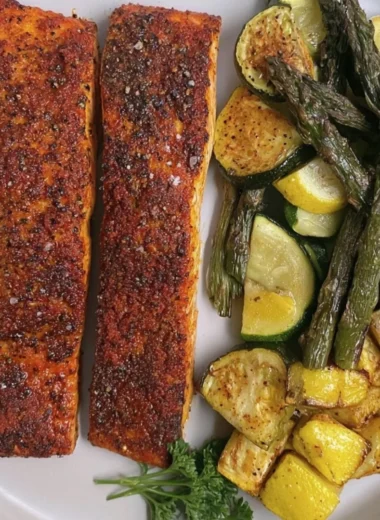Delicious oven baked salmon garnished with herbs and lemon slices.