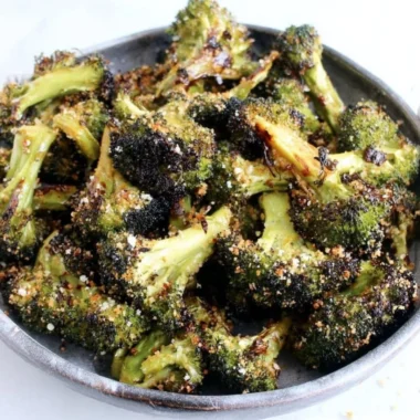 Delicious roasted broccoli served on a plate with seasoning