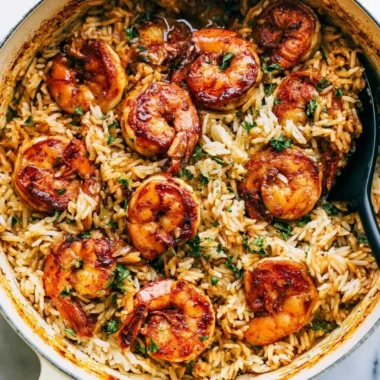 Cajun shrimp served on a bed of rice garnished with herbs