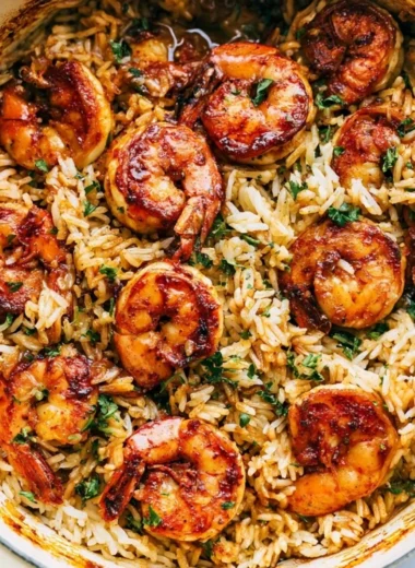 Cajun shrimp served on a bed of rice garnished with herbs