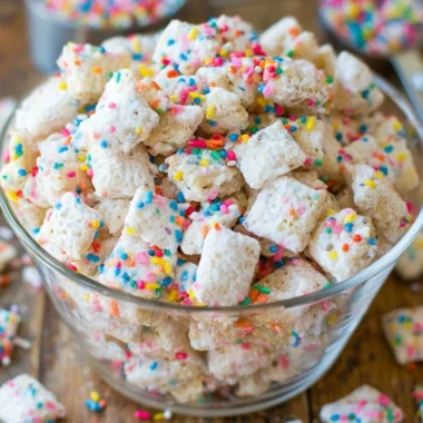 Delicious Cake Batter Puppy Chow in a bowl with colorful sprinkles