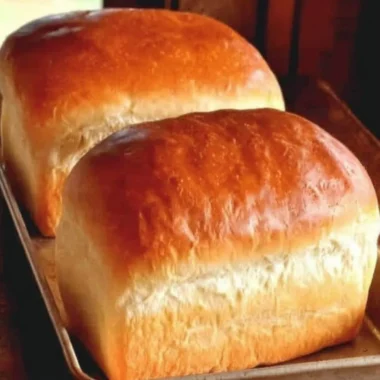 Loaf of freshly baked Homemade Amish White Bread on a wooden table
