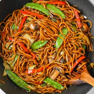 Delicious bowl of Lo Mein noodles topped with vegetables and protein.