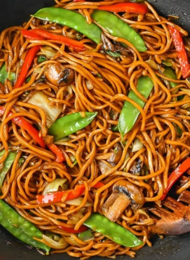 Delicious bowl of Lo Mein noodles topped with vegetables and protein.