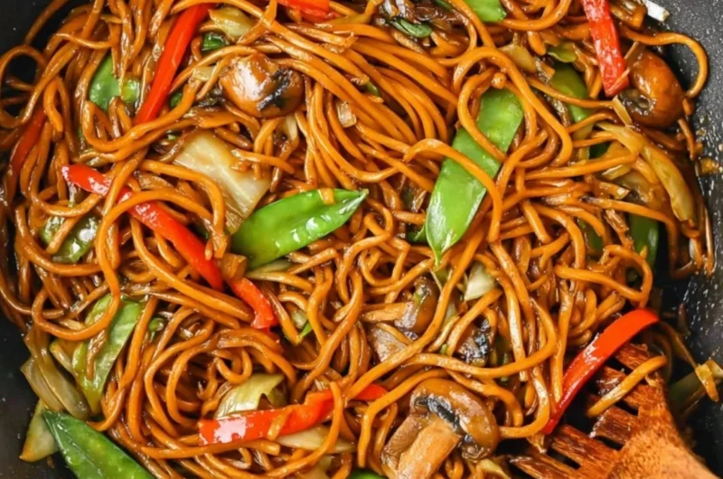 Delicious bowl of Lo Mein noodles topped with vegetables and protein.