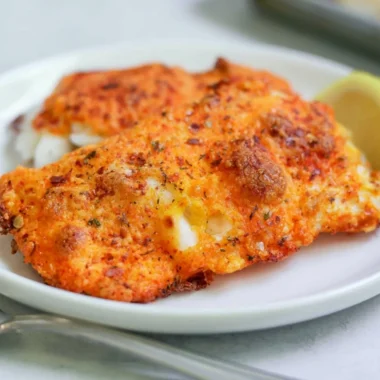 Parmesan Crusted Cod fillet garnished and served on a plate