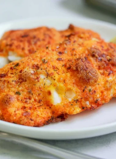 Parmesan Crusted Cod fillet garnished and served on a plate