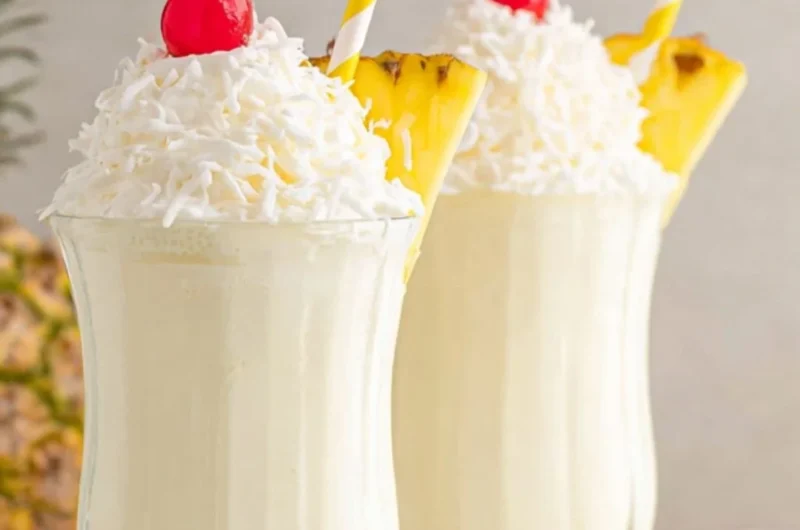 Delicious Pina Colada milkshake topped with whipped cream and pineapple.
