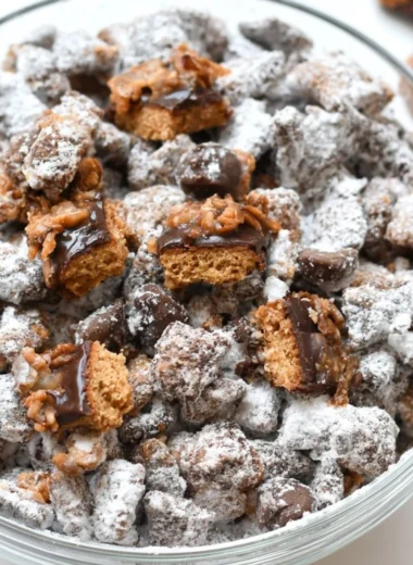 Delicious Samoas Puppy Chow snack in a bowl, featuring chocolate and coconut.