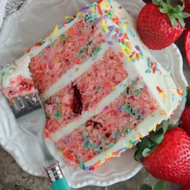 Delicious Strawberry Funfetti Cake topped with fresh strawberries and colorful sprinkles