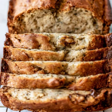 Deliciously baked easy banana bread loaf sliced on a wooden table.