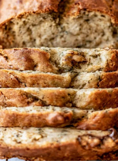 Deliciously baked easy banana bread loaf sliced on a wooden table.
