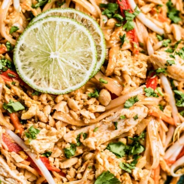 Delicious Chicken Pad Thai served with lime and peanuts.