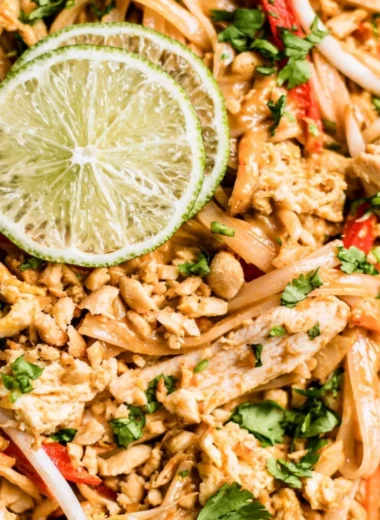 Delicious Chicken Pad Thai served with lime and peanuts.