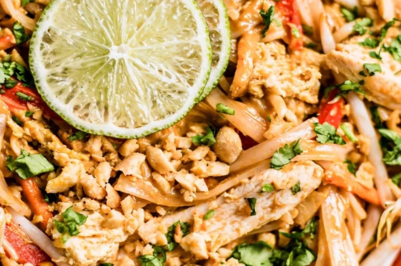 Delicious Chicken Pad Thai served with lime and peanuts.