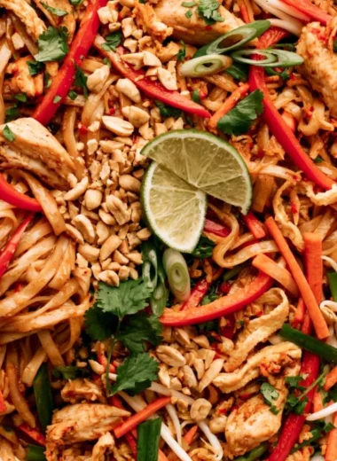 Plate of Chicken Pad Thai with vibrant vegetables and chicken slices