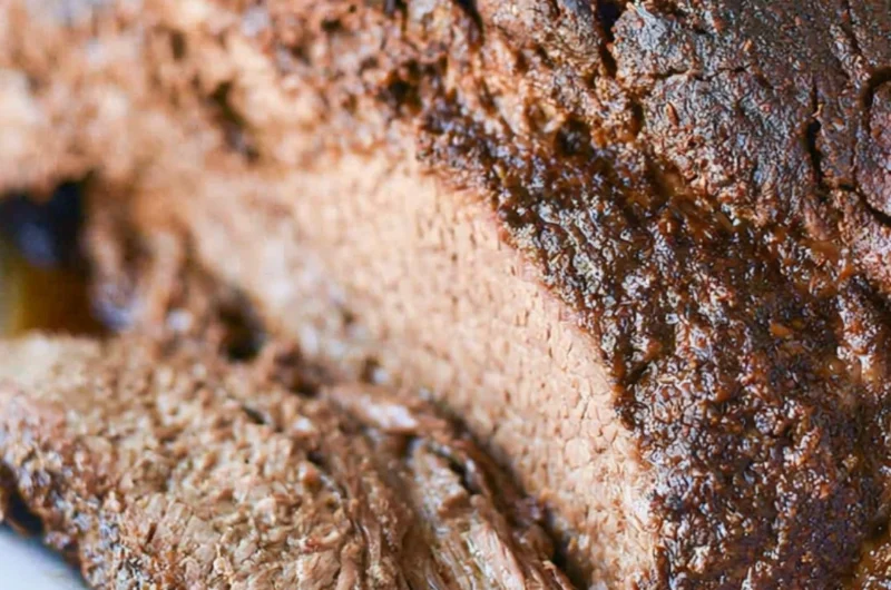 Deliciously cooked classic beef brisket on a wooden cutting board.