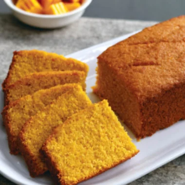 Slice of classic mango cake with fresh mango topping