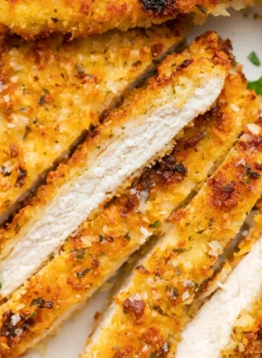 Crispy Parmesan Chicken Cutlets served on a plate with garnish.