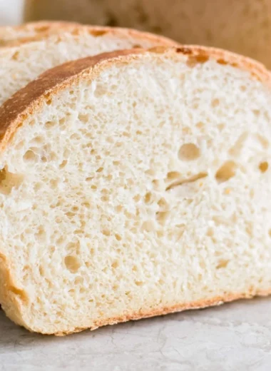 Loaf of super soft easy sourdough sandwich bread on a wooden cutting board