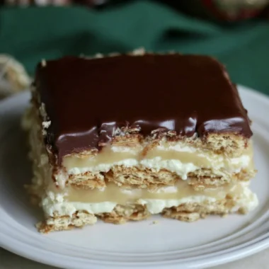 Delicious Eclair Icebox Cake layered with cream and chocolate on a serving plate