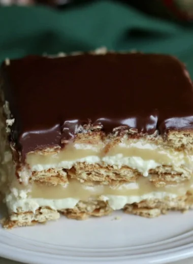 Delicious Eclair Icebox Cake layered with cream and chocolate on a serving plate