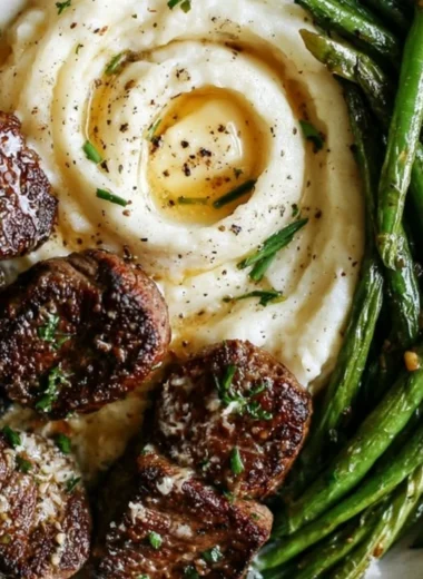 Delicious garlic parmesan steak bites plated with creamy mashed potatoes.