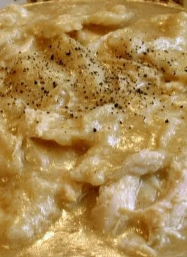 Bowl of homemade chicken and dumplings with vegetables and herbs