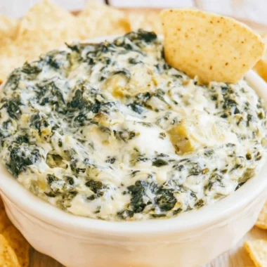 Delicious slow cooker spinach artichoke dip served with tortilla chips