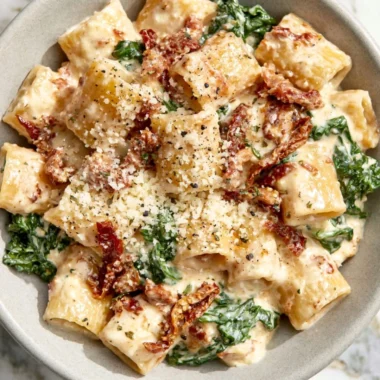 Delicious plate of sun-dried tomato pasta garnished with fresh herbs