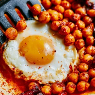 Plate of chickpea fried eggs garnished with herbs and spices
