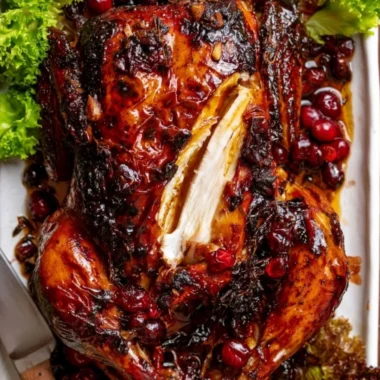 Whole roast chicken with cranberry-maple glaze on a serving platter